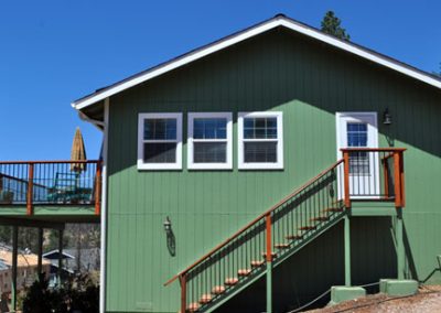 green home with stairs outside